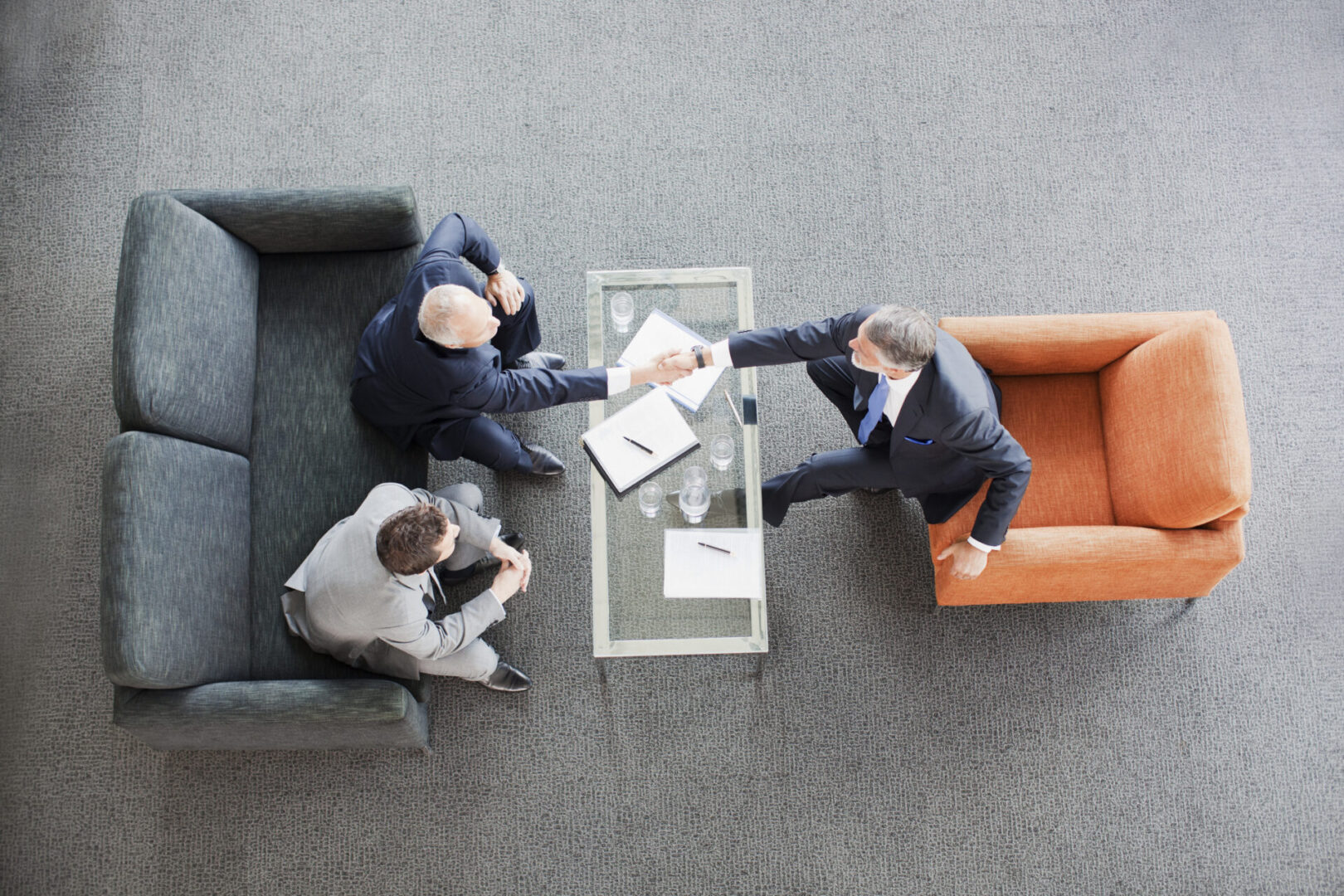 Businessmen shaking hands in office meeting.