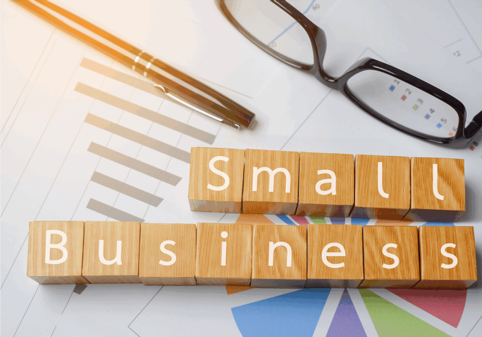 Small business blocks with glasses and graphs.